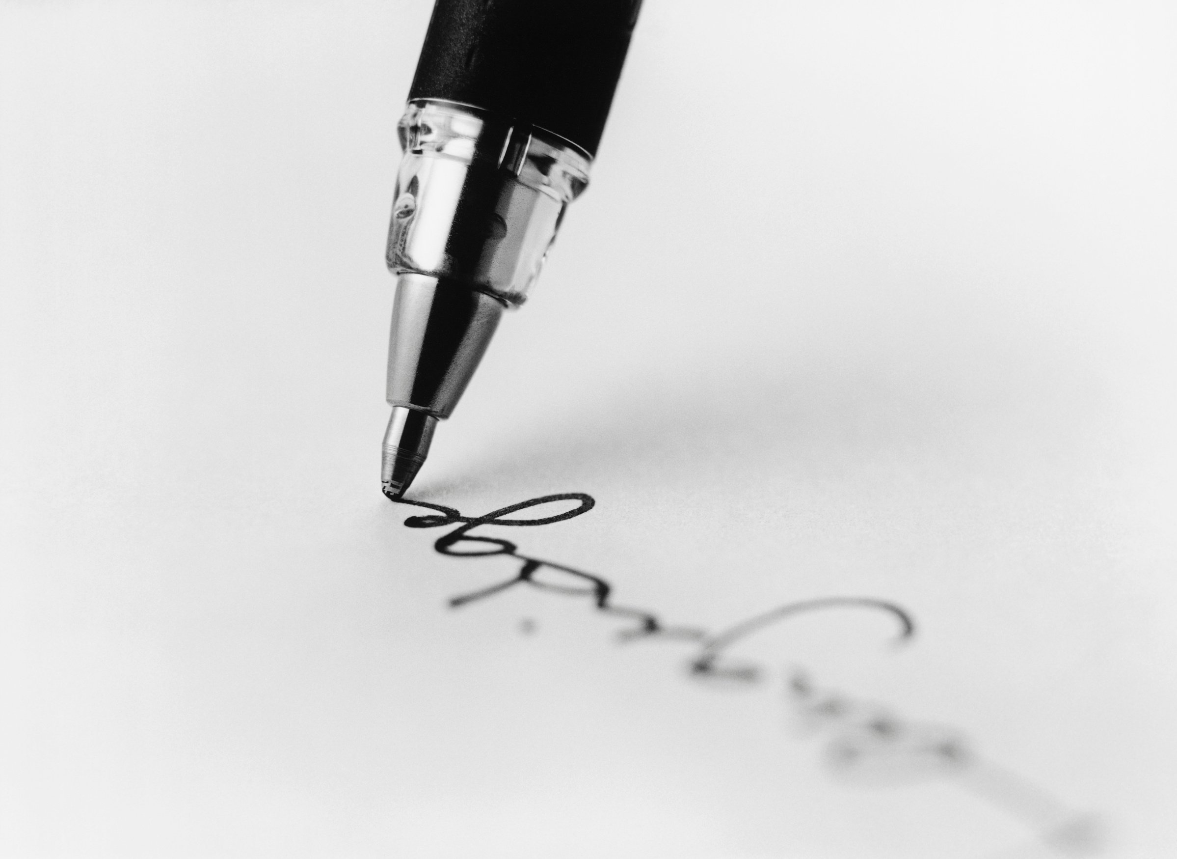 tip of pen writing on paper (b&w) (close-up)